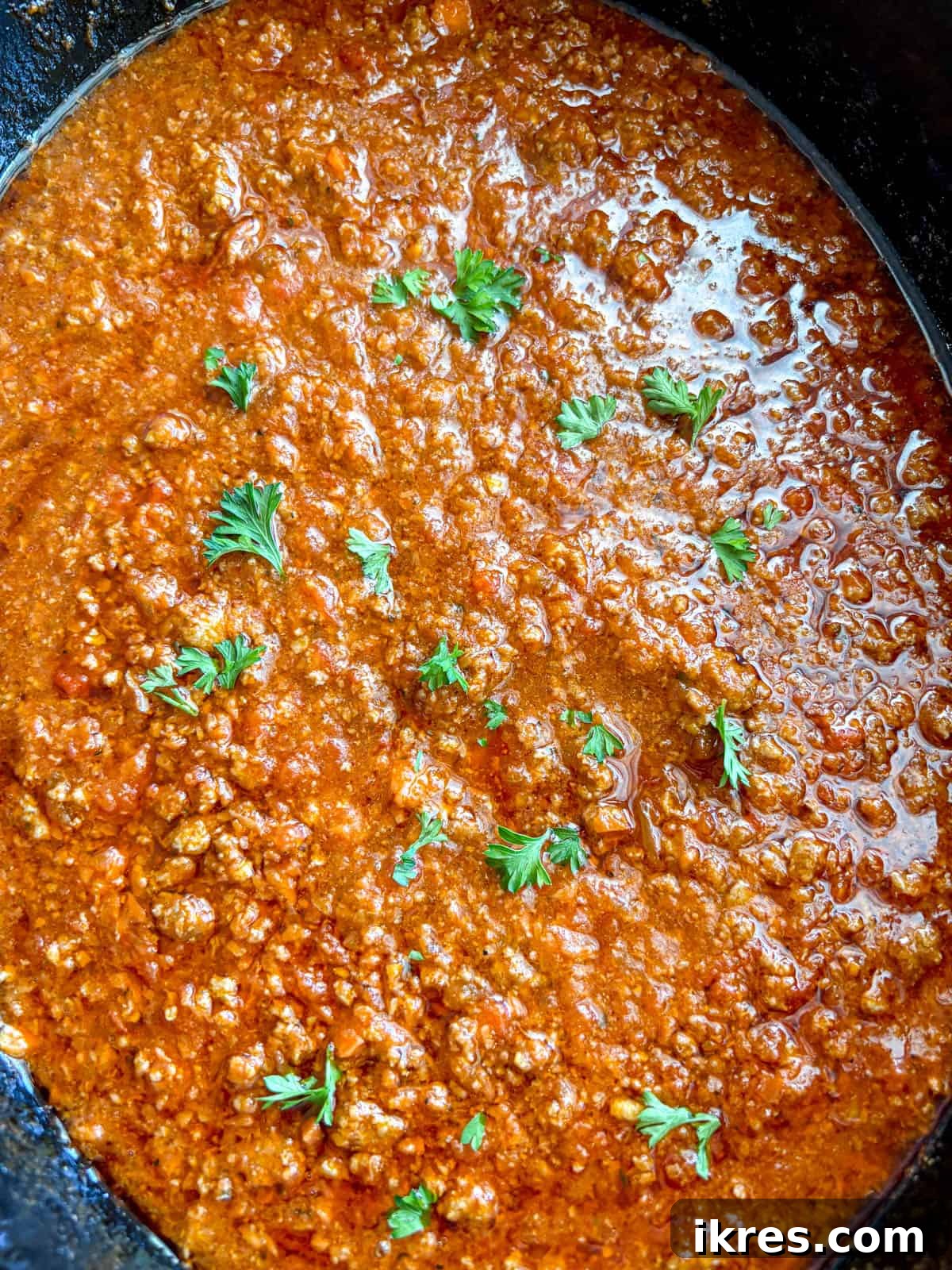 The slow cooker meat sauce after cooking, rich and deeply colored.