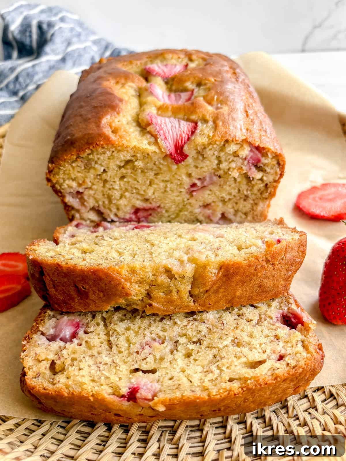 Strawberry Swirl Banana Bread 11 Several moist slices of strawberry banana bread, garnished with fresh mint, arranged artfully on a white plate.