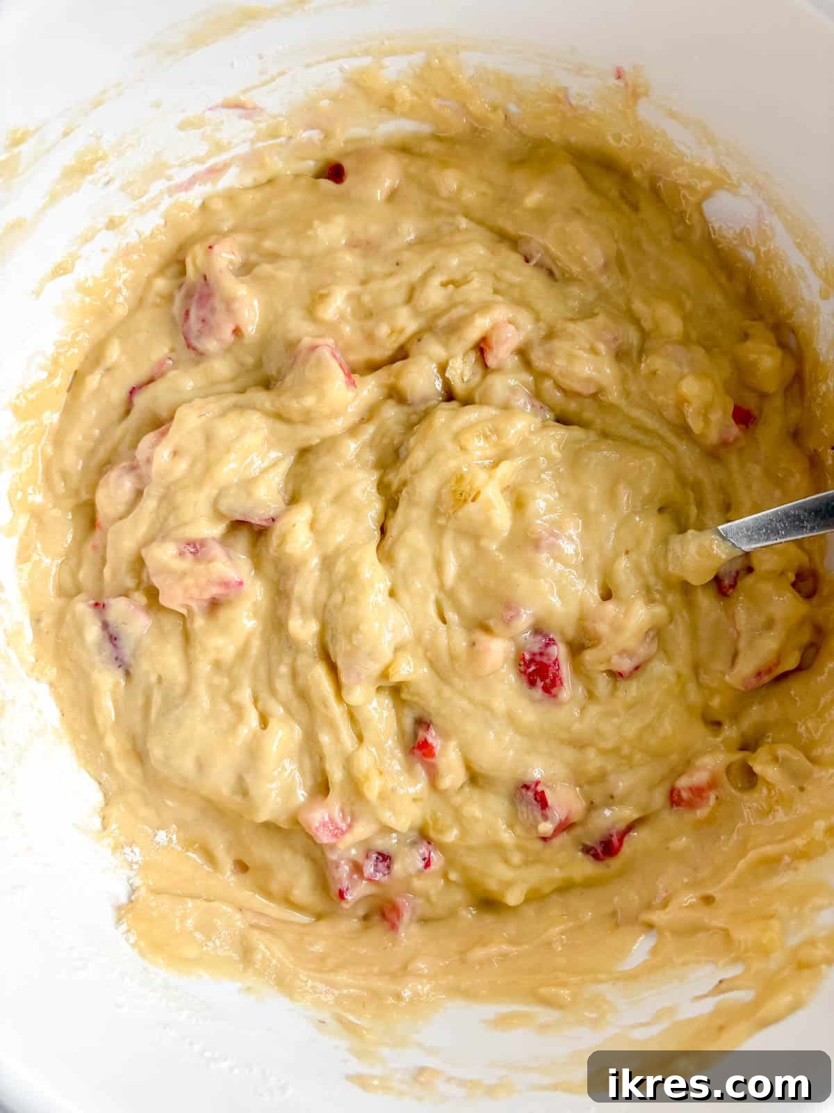 Strawberry Swirl Banana Bread 8 Flour-coated chopped strawberries being gently folded into the banana bread batter.