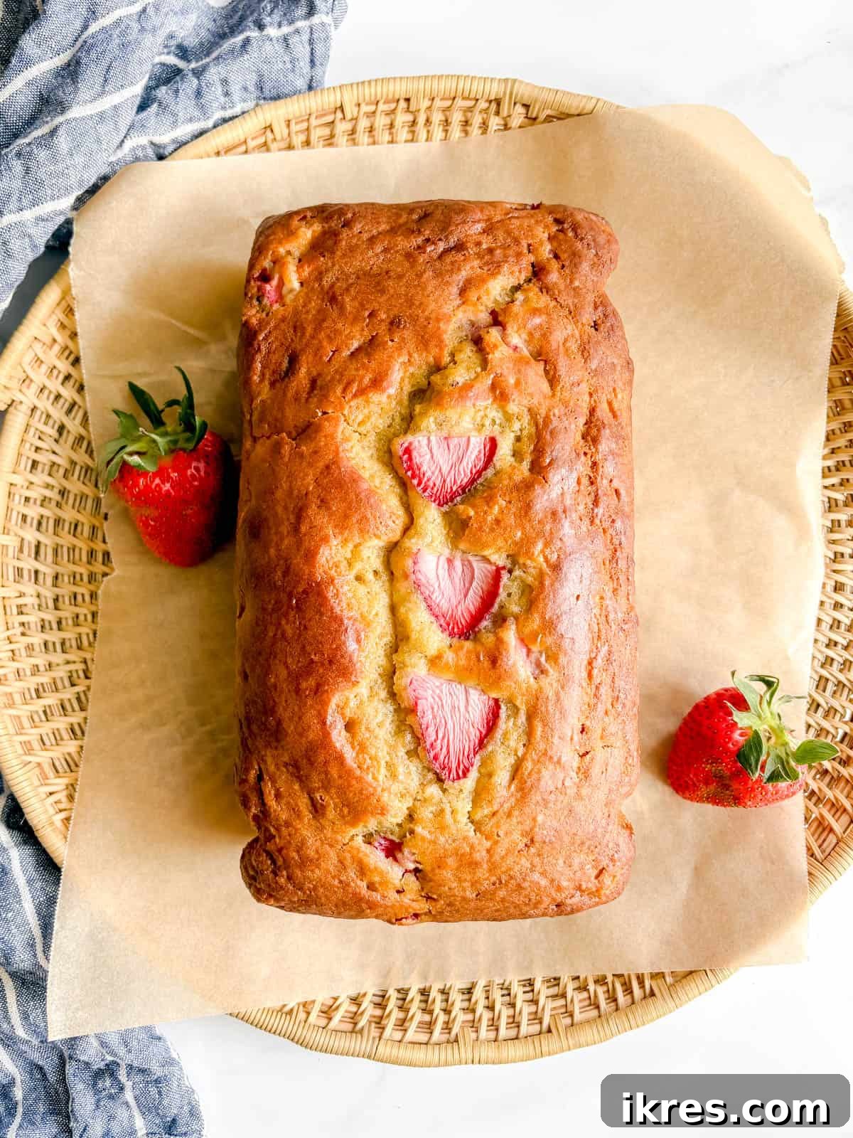 Strawberry Swirl Banana Bread 10 A freshly baked, golden-brown loaf of strawberry banana bread, cooling on a wire rack.