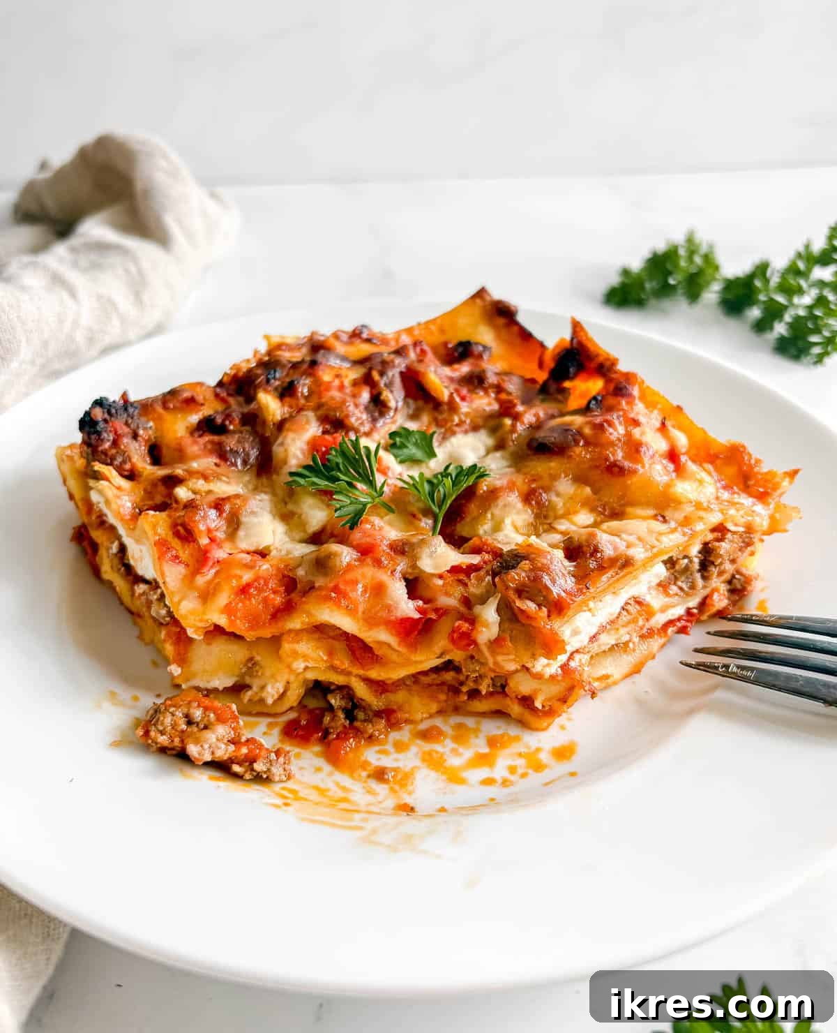 Effortless Greek Yogurt Lasagna 2 A perfect slice of easy no-boil ground beef lasagna on a white plate, ready to eat.