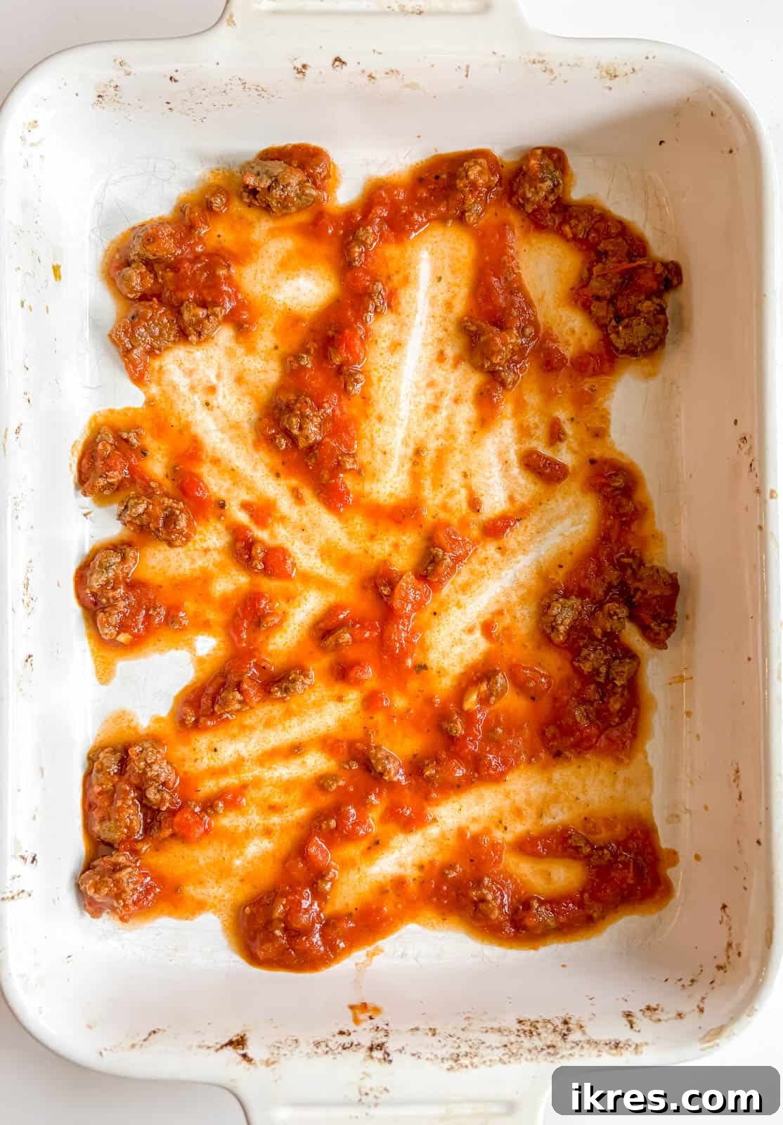 Effortless Greek Yogurt Lasagna 6 A thin layer of meat sauce spread on the bottom of a 9x13 inch baking dish.