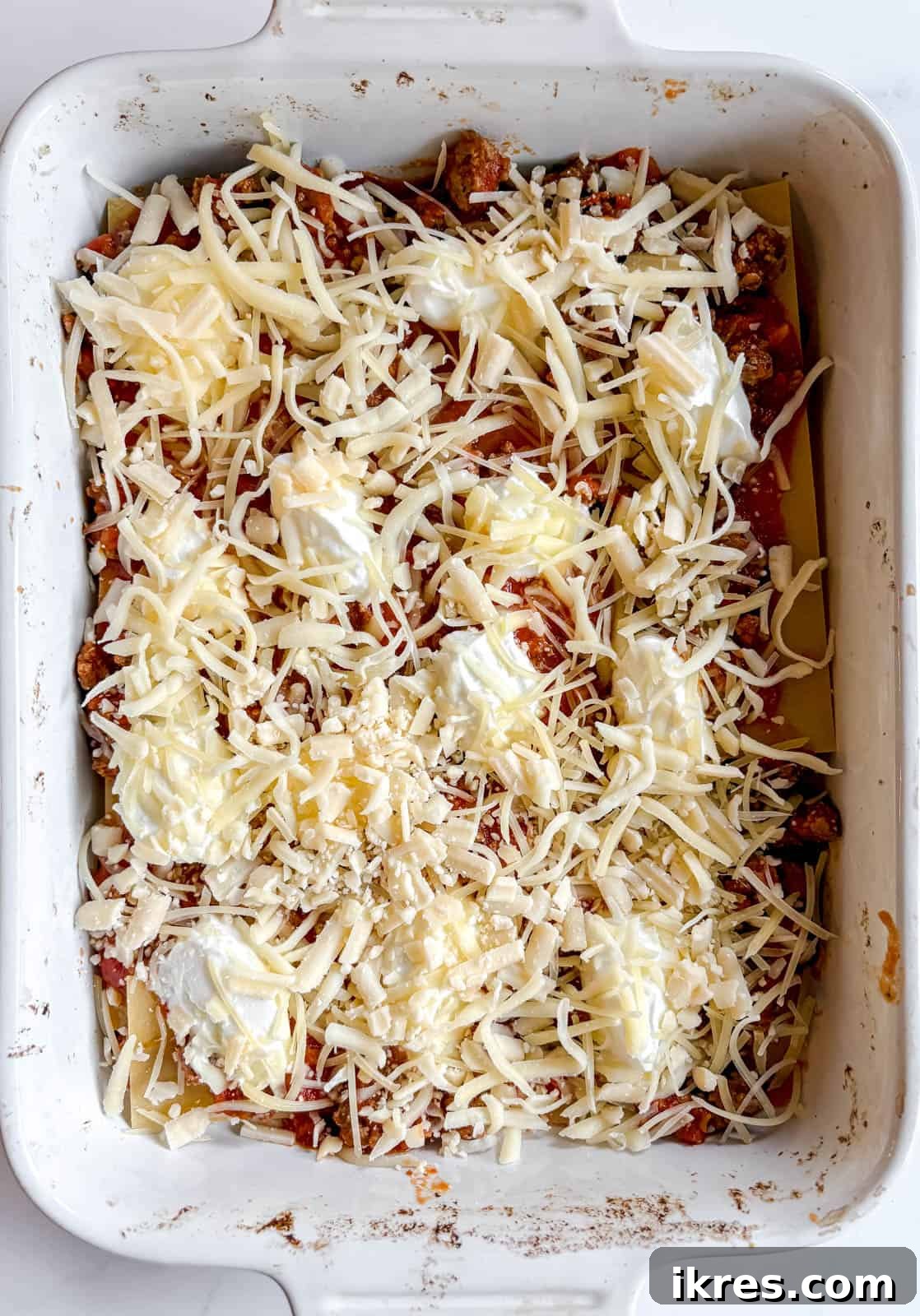 Effortless Greek Yogurt Lasagna 9 A generous layer of shredded mozzarella, cheddar, and Parmesan cheese sprinkled over the sauce.