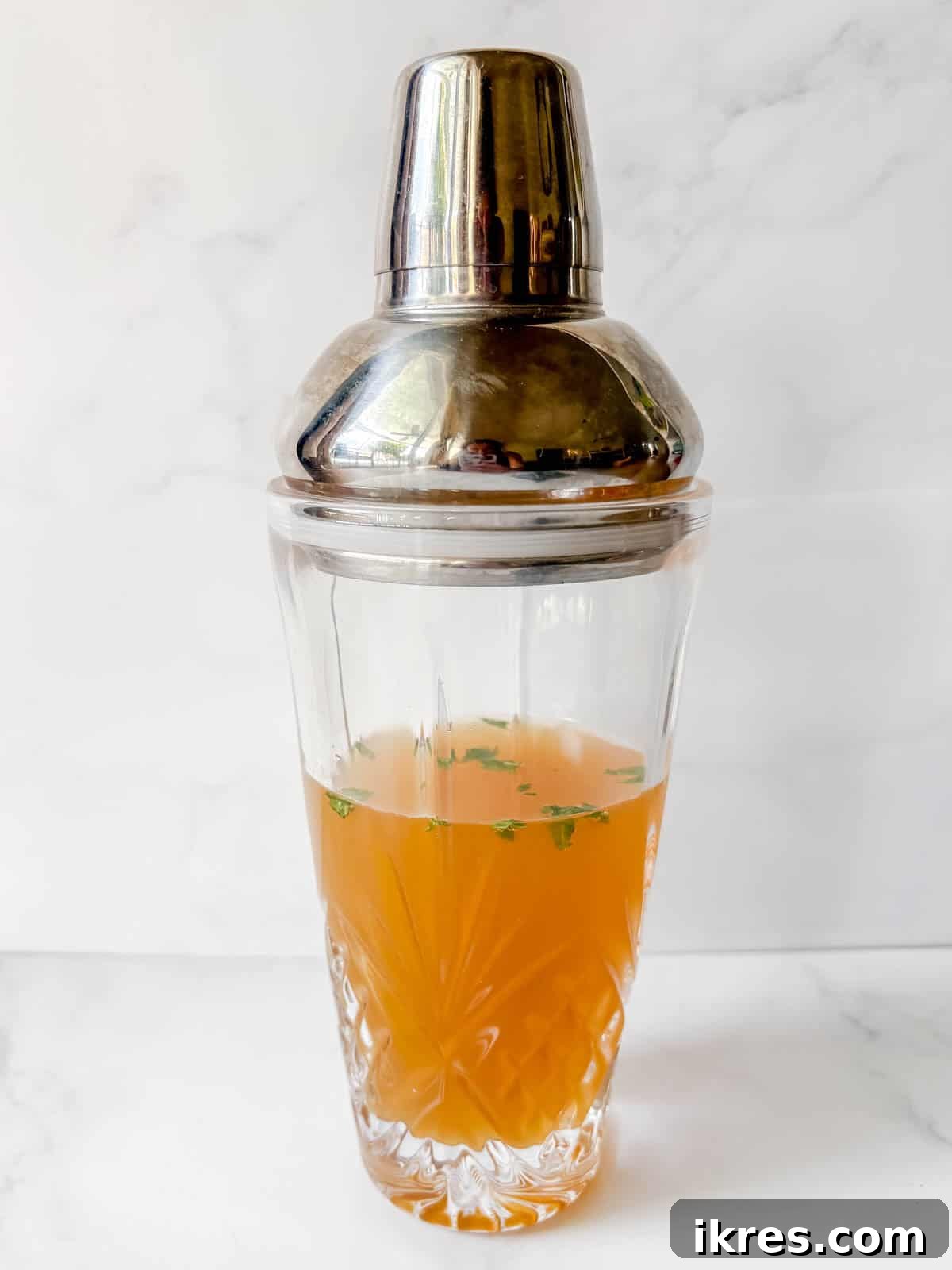 All the ingredients needed to make a passion fruit cocktail in a cocktail shaker.