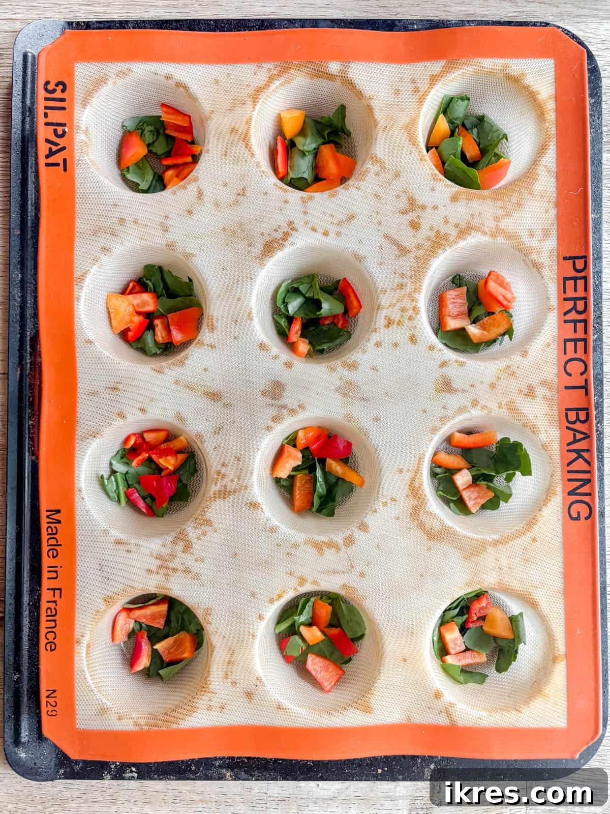 Red pepper and spinach in muffin tins.