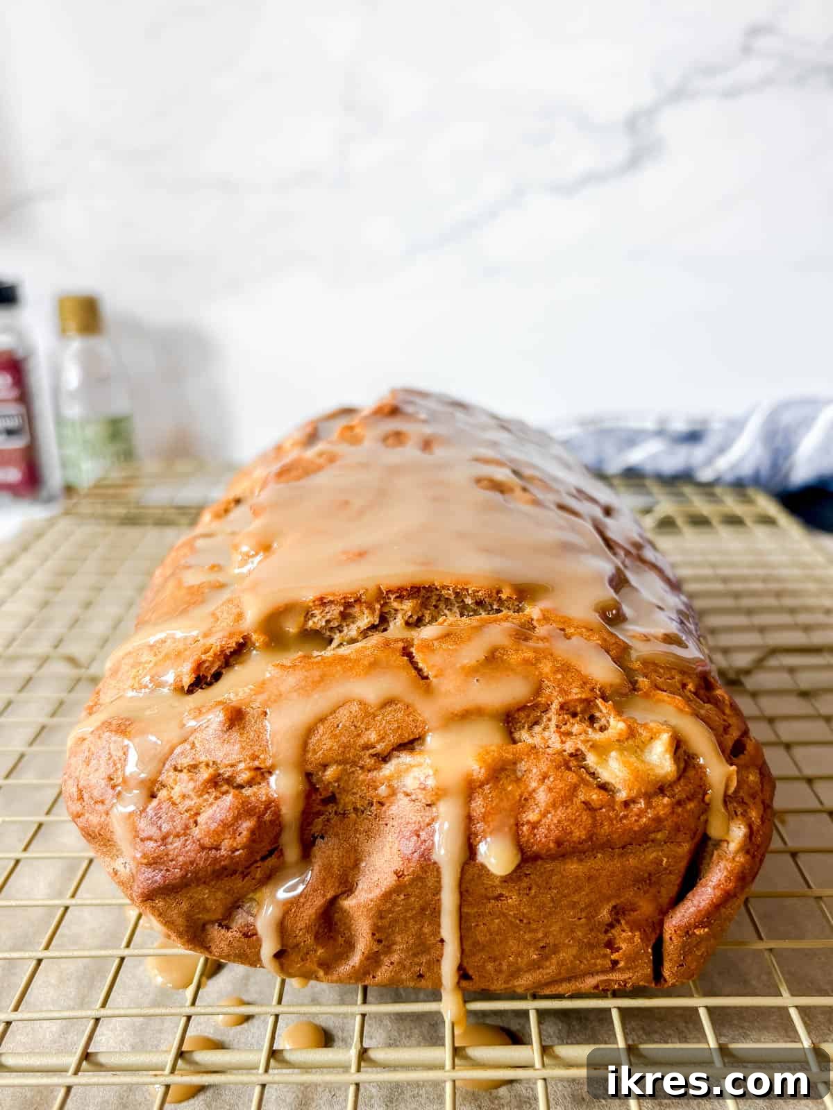 Maple banana bread covered in maple glaze on a drying rack.