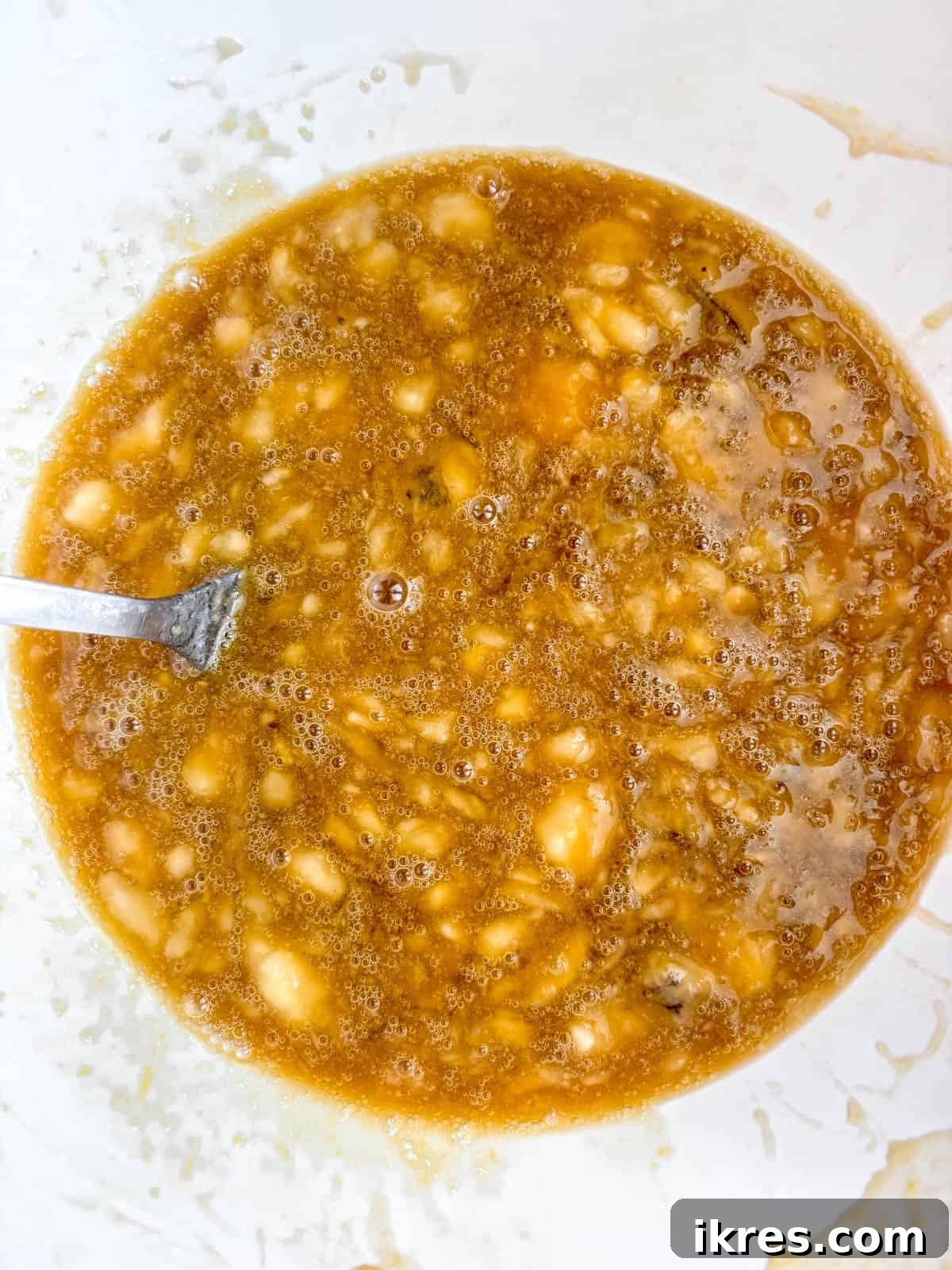 Wet ingredients for maple banana bread mixed together in a bowl.