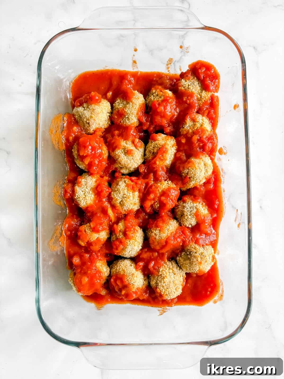 Chicken parmesan meatballs covered in marinara sauce.