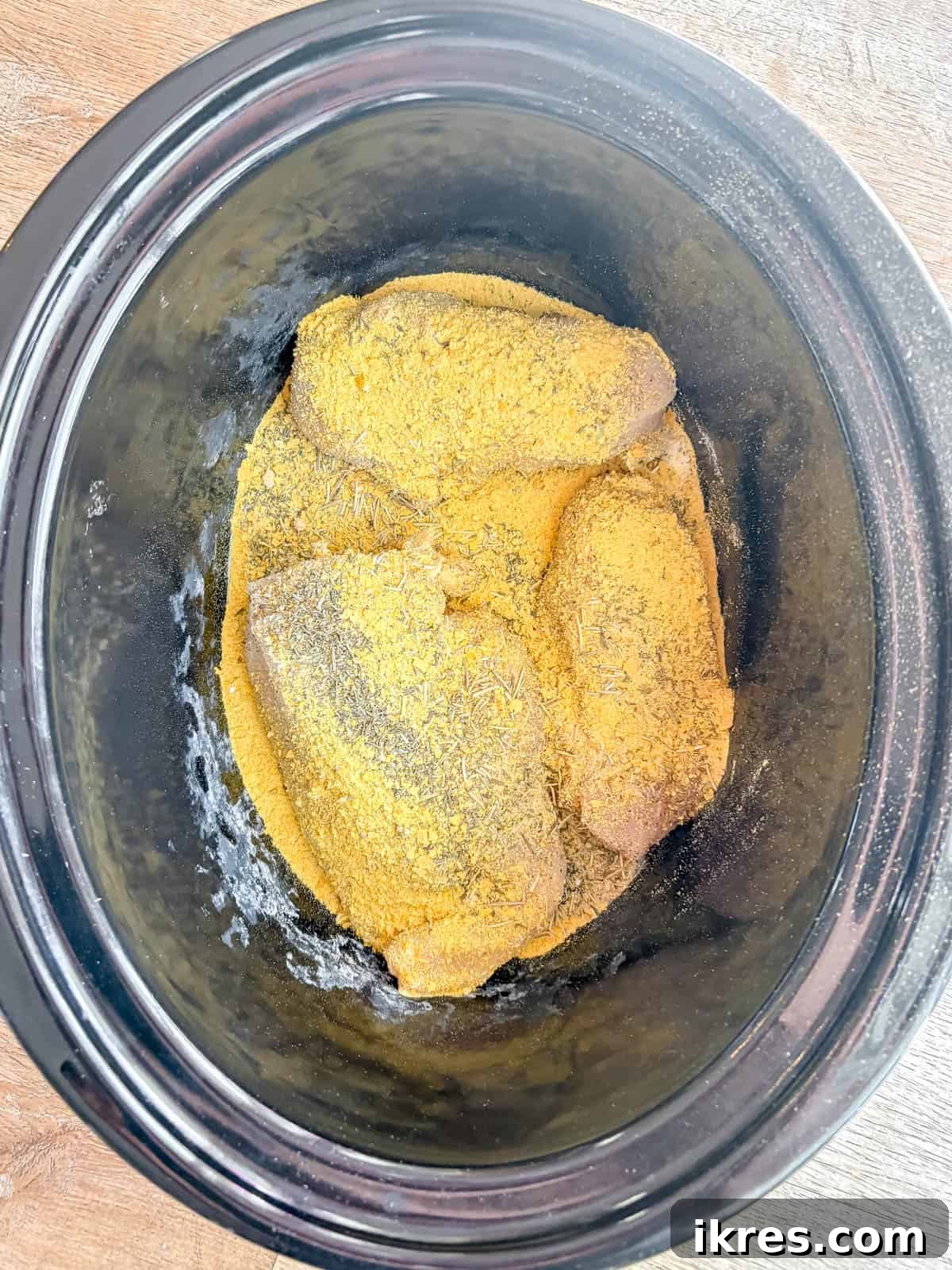 Chicken and spices in a crockpot.